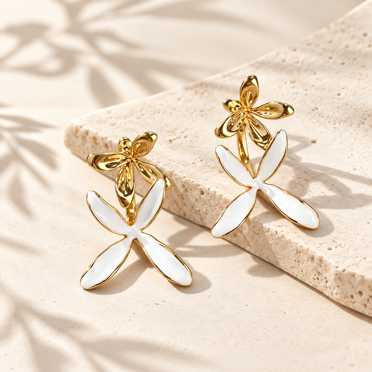 Gold-tone and white sculptural orchid earrings with botanical forms