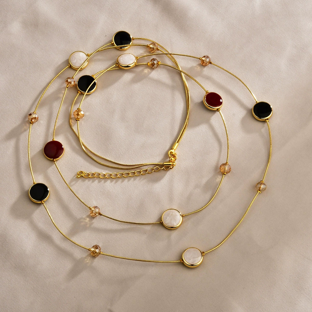 Close-up of black and red layered necklace with gold-tone copper chains and crystal bead details