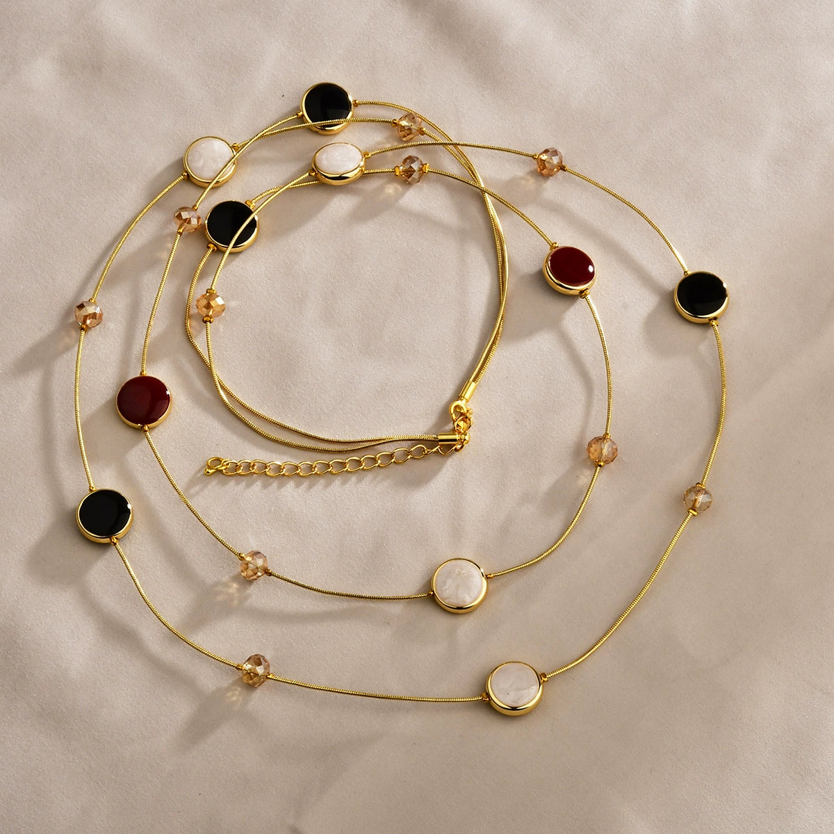 Close-up of black and red layered necklace with gold-tone copper chains and crystal bead details