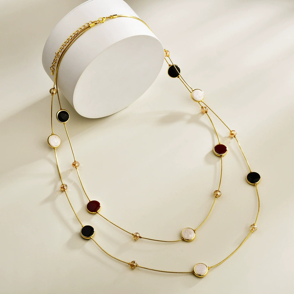 Black and red layered long necklace with gold-tone chains and crystal bead accents