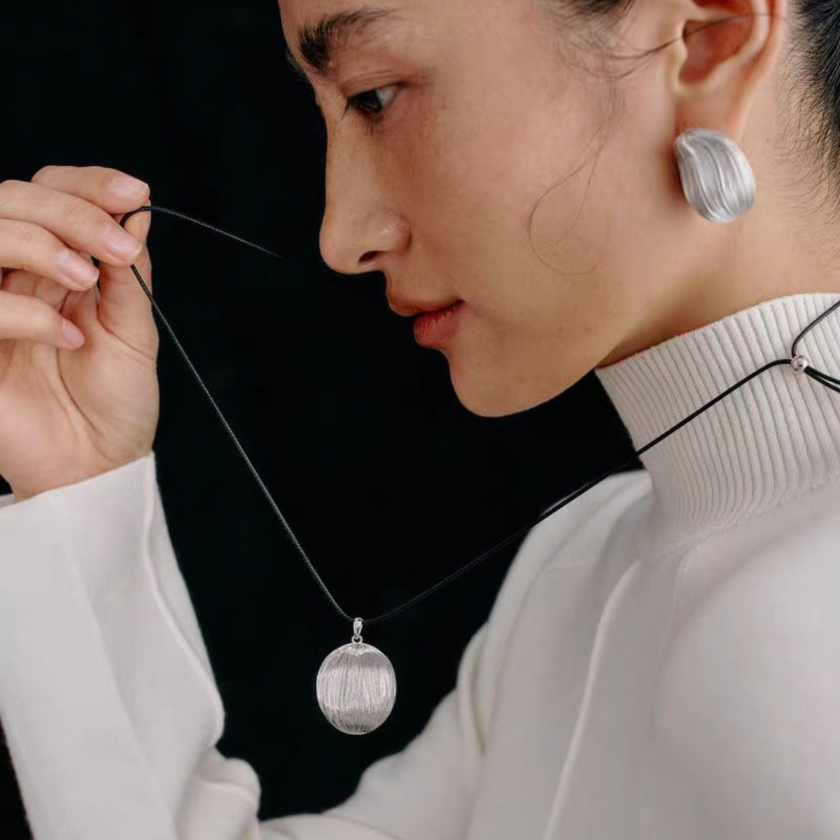 Model wearing the Silver-Tone Bound Light brushed necklace and sculptural stud earrings