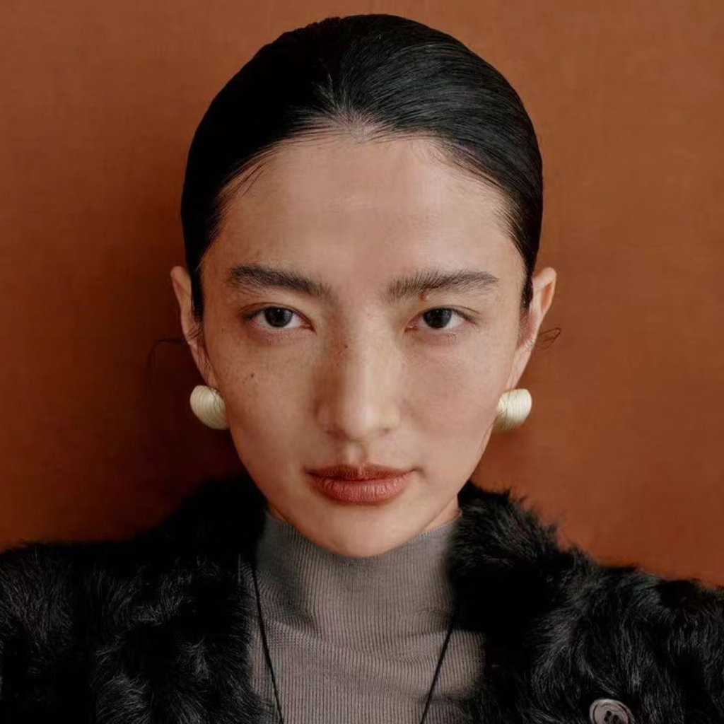 Model wearing Bound Light brushed sculptural stud earrings in Small Gold-Tone