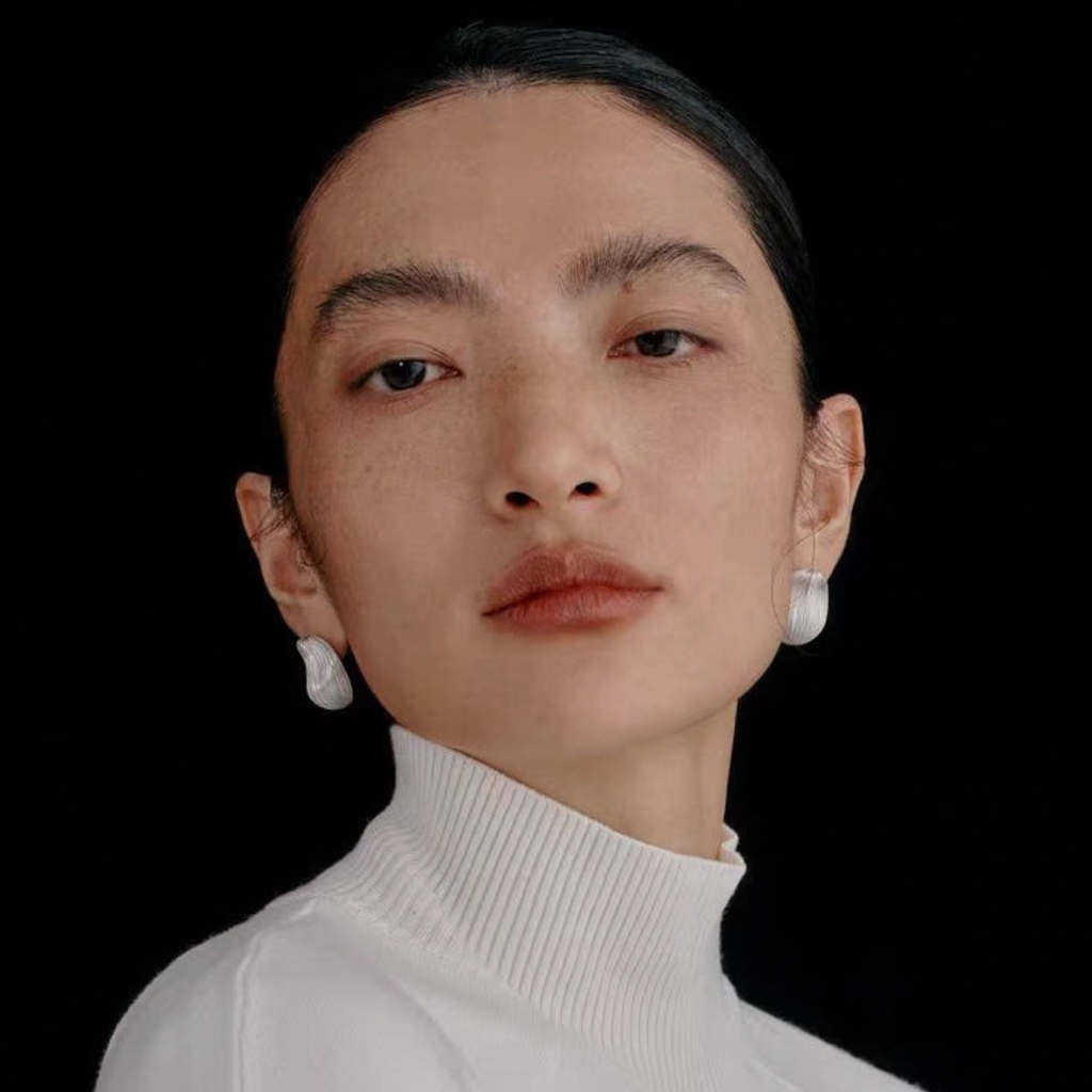 Model wearing Bound Light brushed sculptural stud earrings in Small Silver-Tone