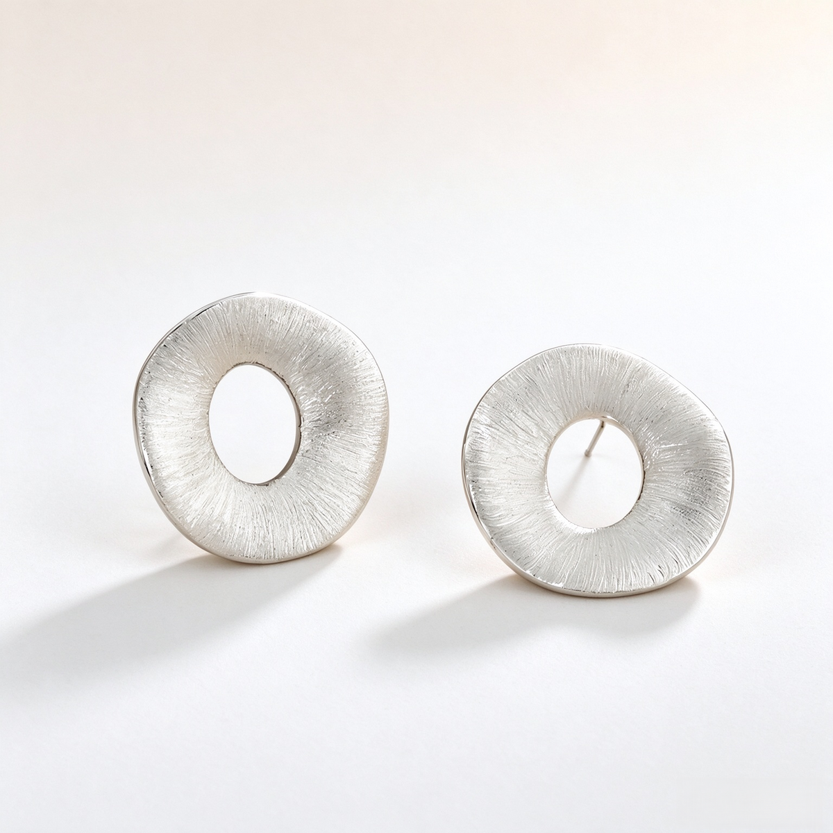 Silver-tone brushed open-center sculptural stud earrings
