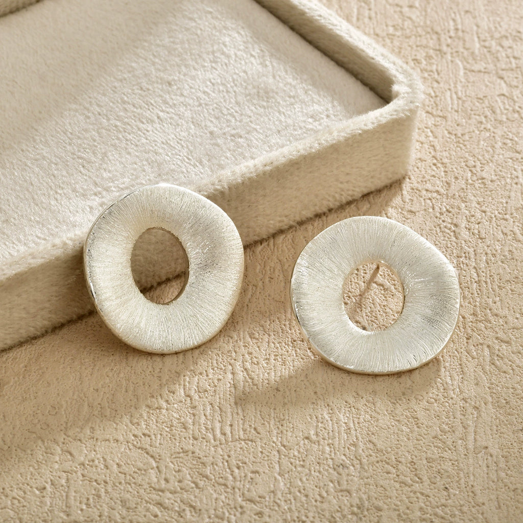 Silver-tone brushed halo stud earrings in a neutral setting