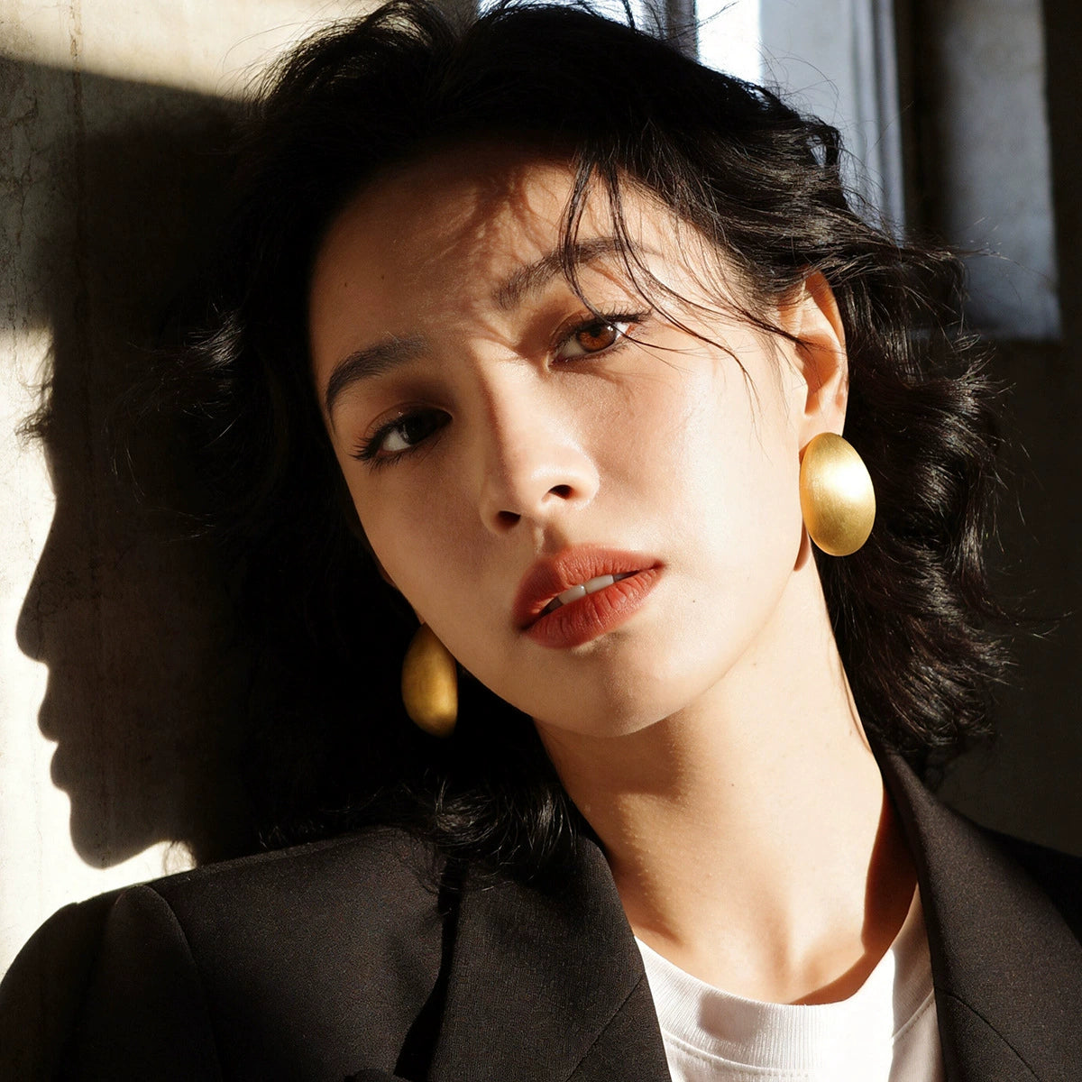Model wearing Gold-Tone brushed oval statement stud earrings