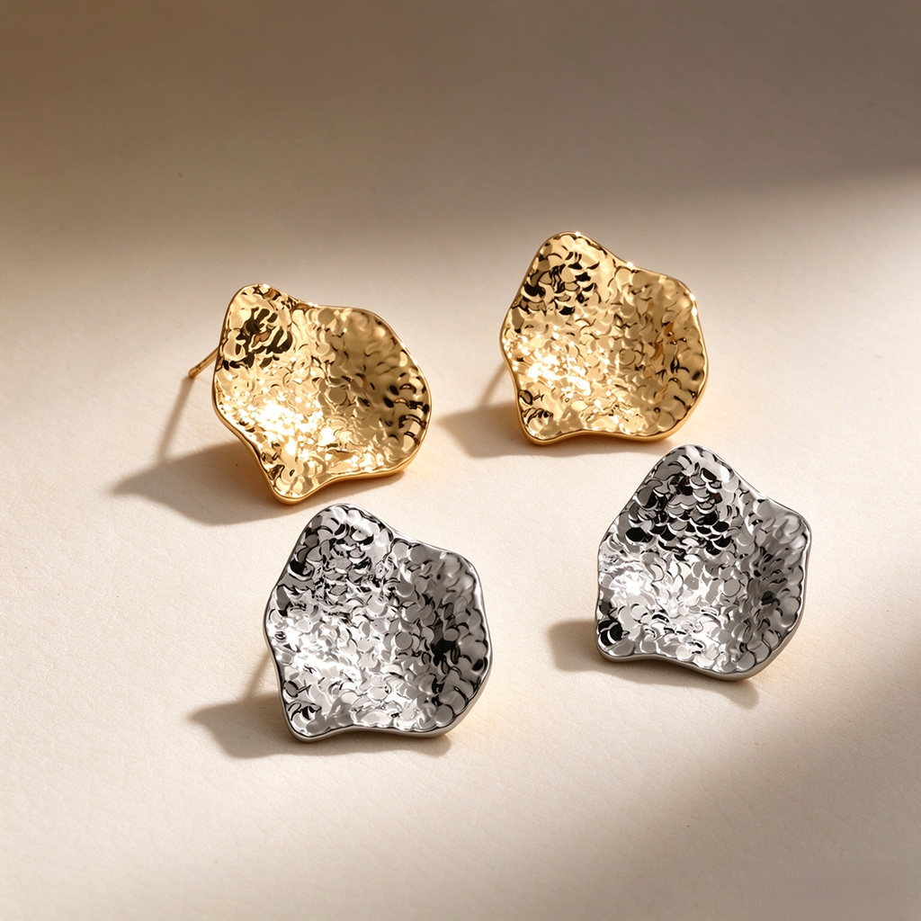 Crinkled sculptural stud earrings in an irregular shape, available in gold-tone and silver-tone finishes