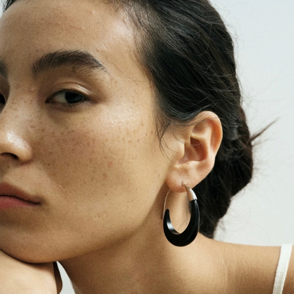 Ebony wood and silver-tone hoop earring close-up