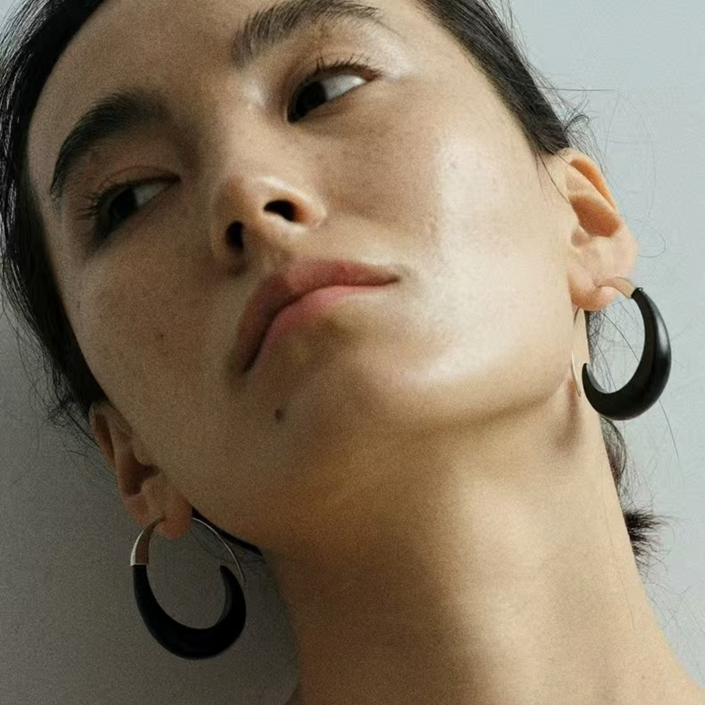 Close-up of ebony wood hoop earrings worn