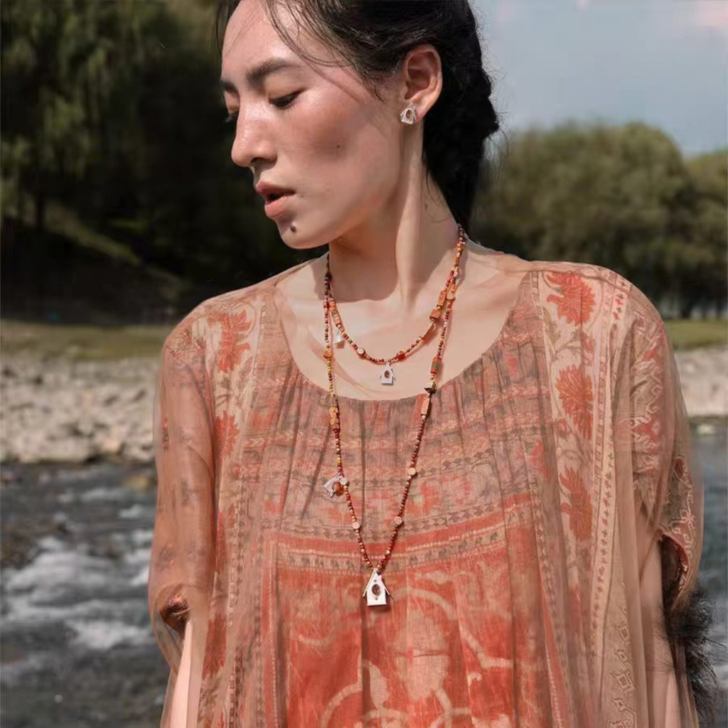 Model wearing the House Charm short and long mixed-stone necklaces styled as a layered set with matching earrings