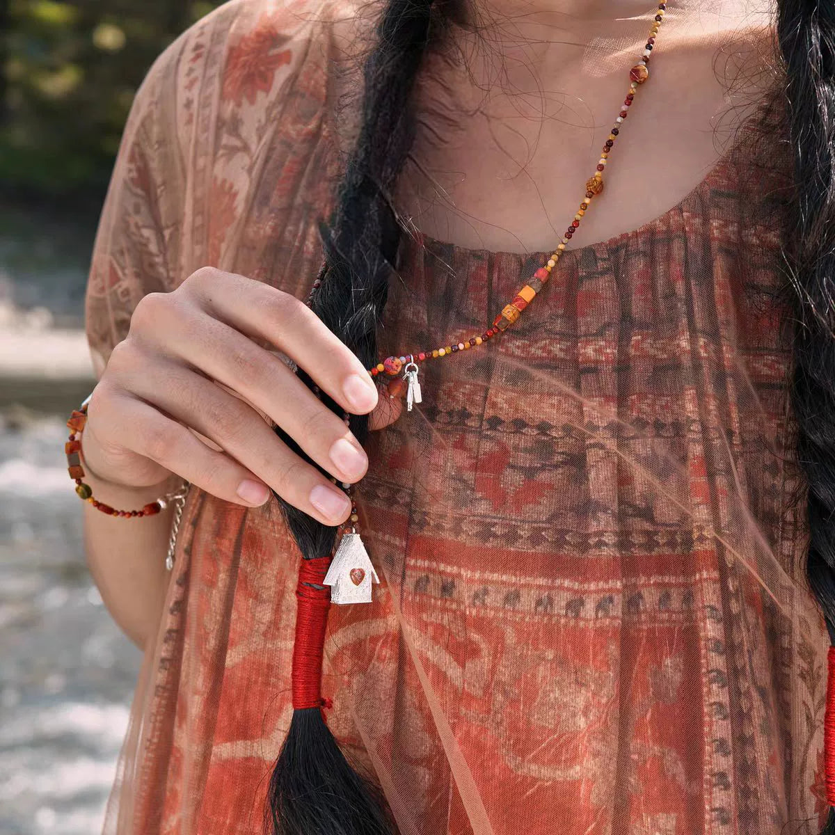 House Charm mixed-stone long necklace worn at the collarbone