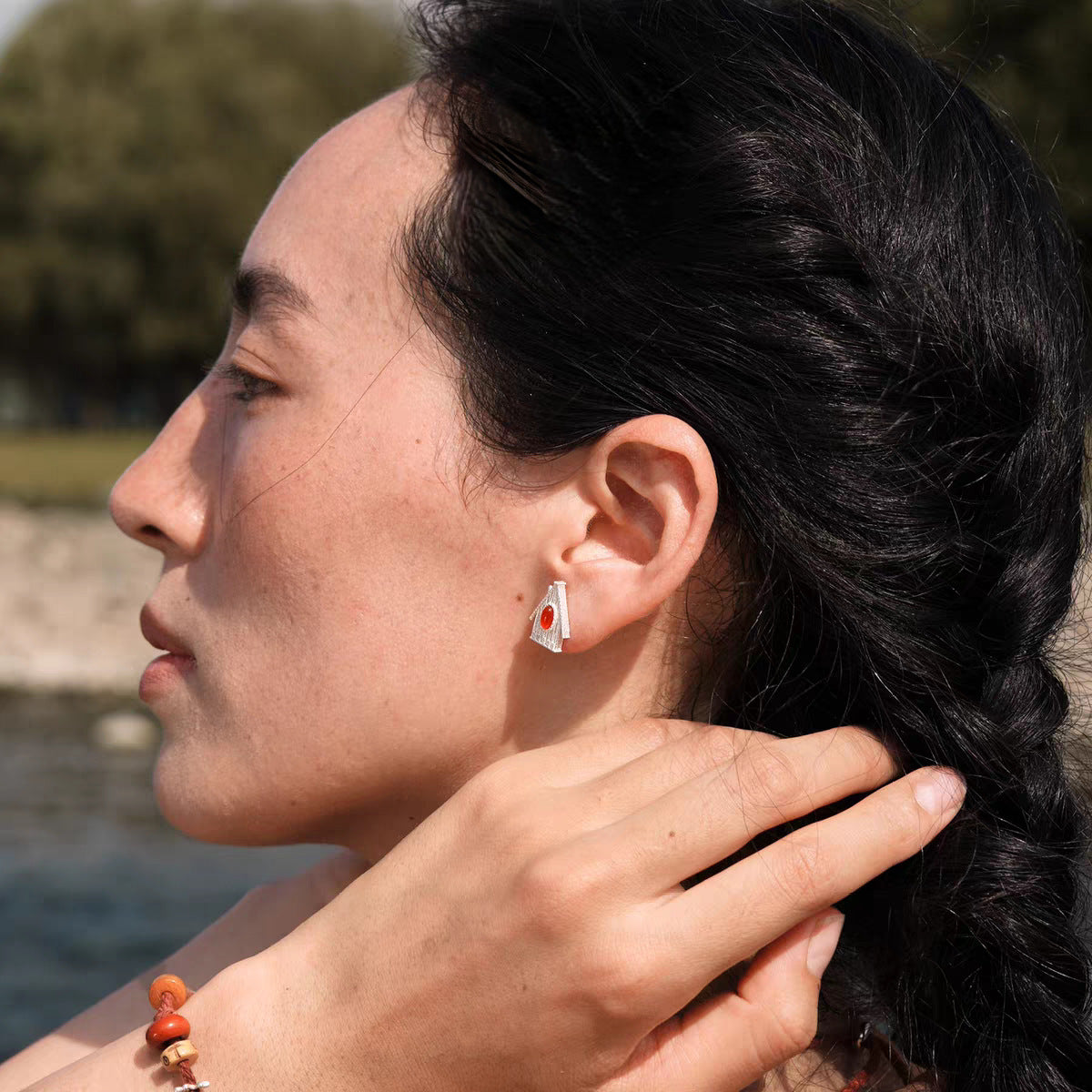 House Charm stone stud earrings in Red worn on the ear