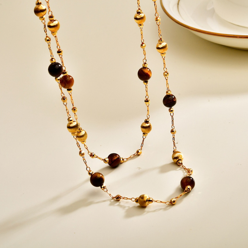 Close-up of tiger eye beads and gold-tone details on layered long necklace