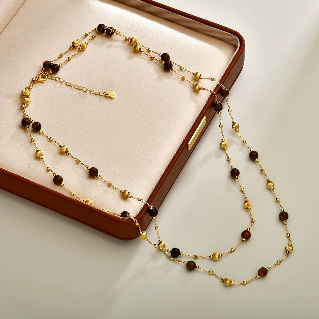 Layered tiger eye long necklace arranged on a jewelry display box