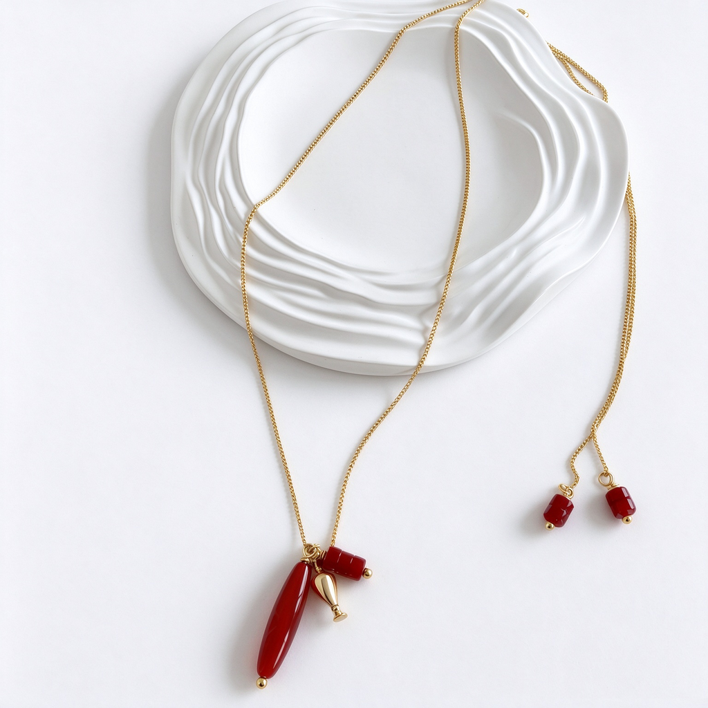 Gold-tone long bead charm pendant necklace with elongated pendant and accent charms