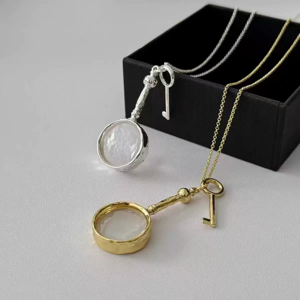 Gold and silver magnifying glass pendants with key charms