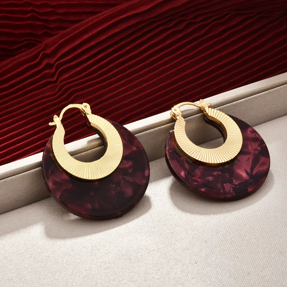 Burgundy marbled acetate statement hoop earrings in a warm editorial setting