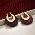Burgundy marbled acetate statement hoop earrings in a warm editorial setting