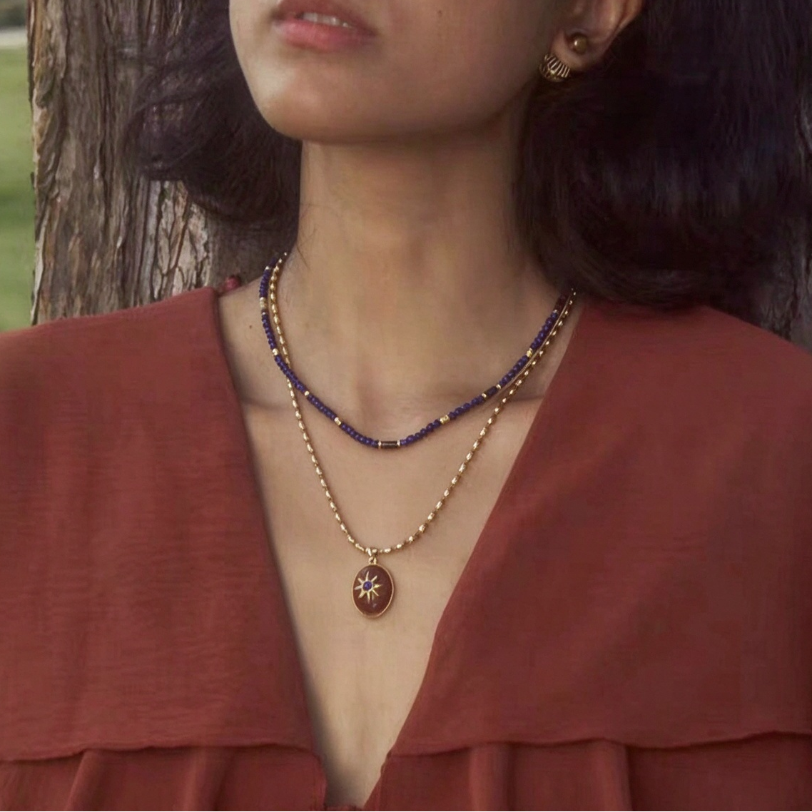 Model wearing two Motu Blue necklaces together in a layered look