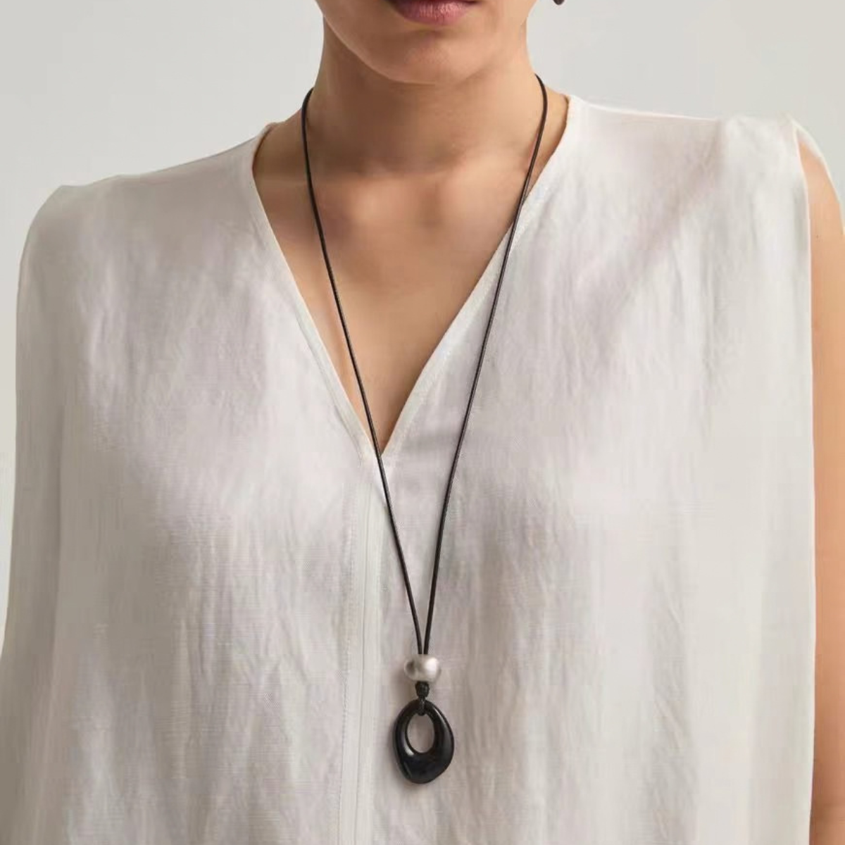 Openwork Black Onyx Cord Necklace worn long with brushed silver-tone detail