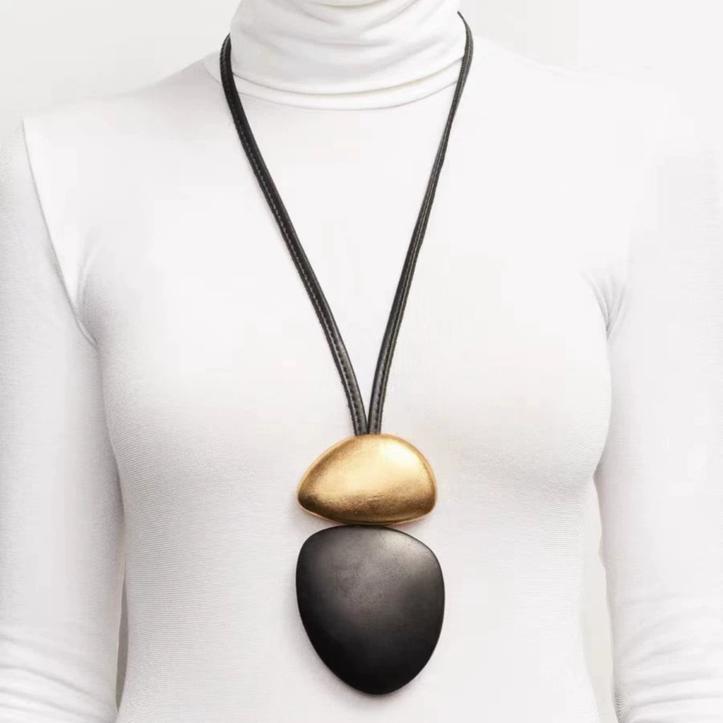 Dark wood sculptural pendant necklace with gold-tone brass detail