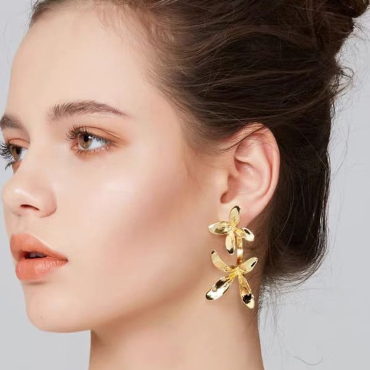 Model wearing Sculptural Orchid stud earrings in Gold-Tone