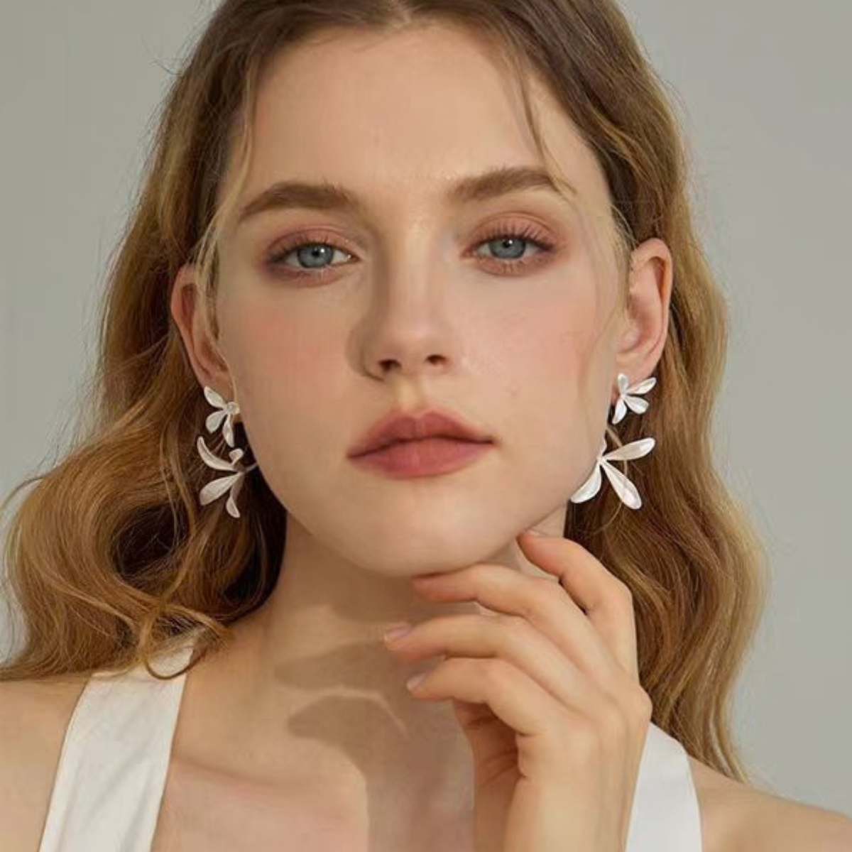 Model wearing Sculptural Orchid stud earrings in silver-tone