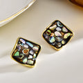 Close-up of black-back abalone square stud earrings with natural iridescent shell fragments