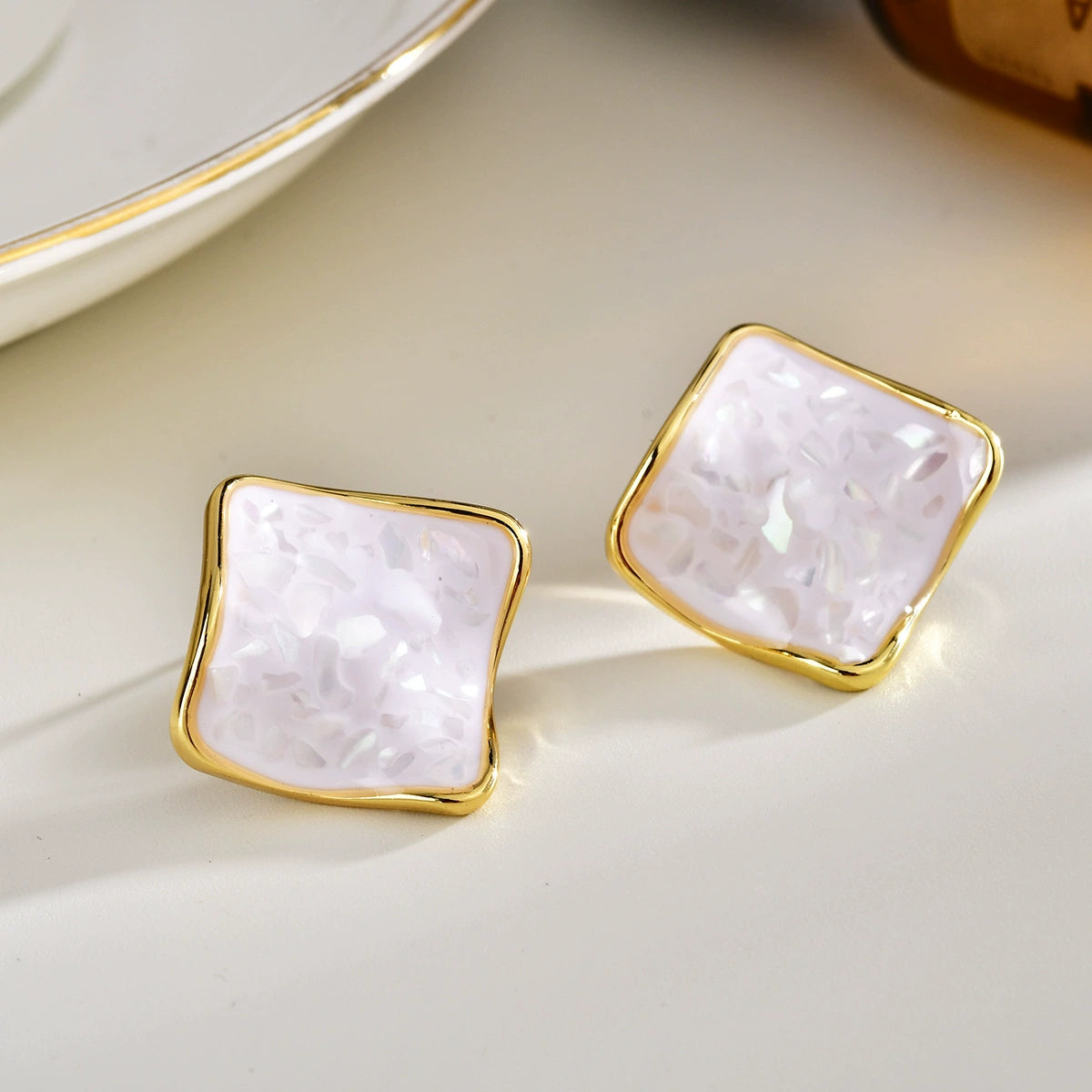 White shell square stud earrings with softly iridescent fragments and gold-tone frame
