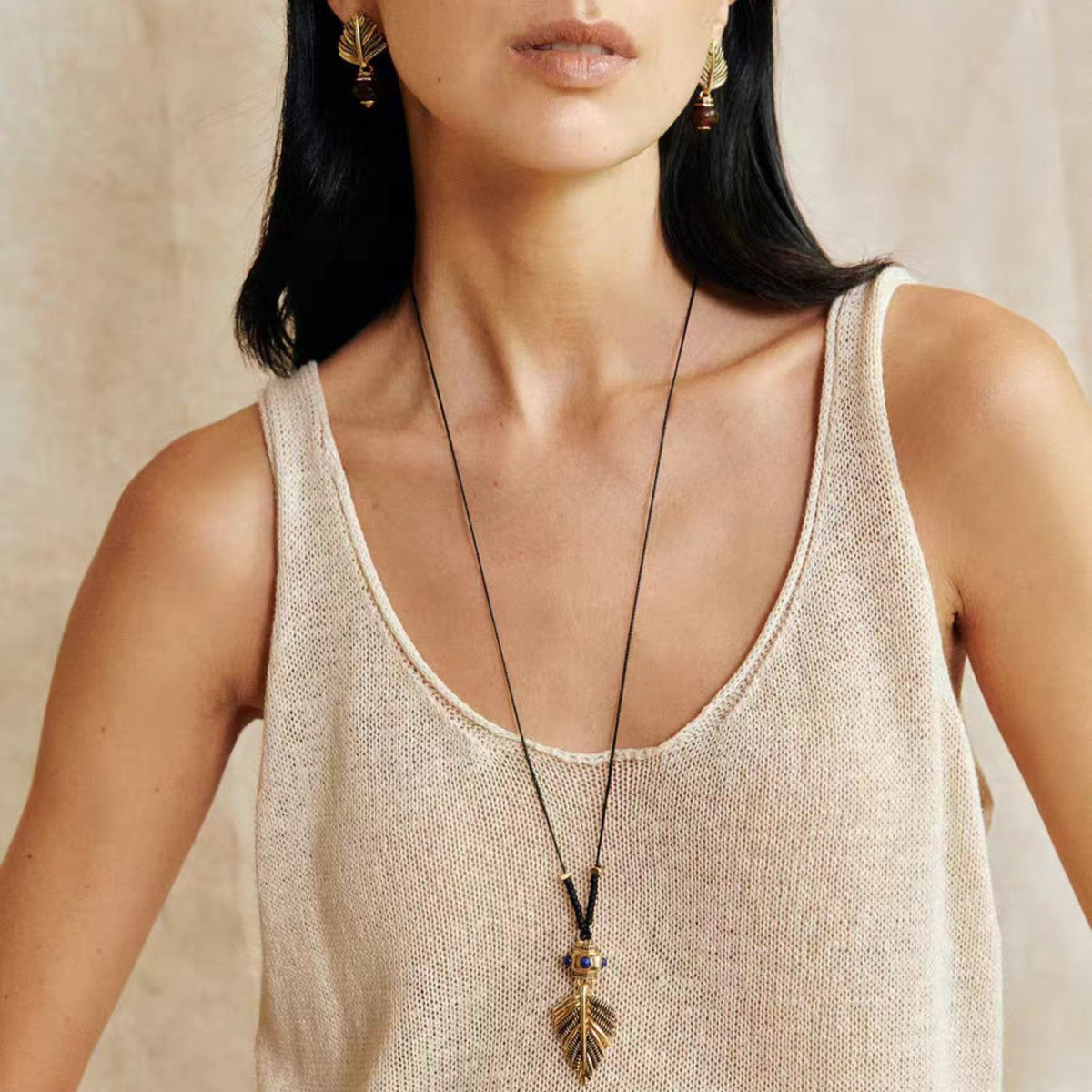 Swaying Palm gold-tone pendant necklace and coordinating botanical stud earrings styled together