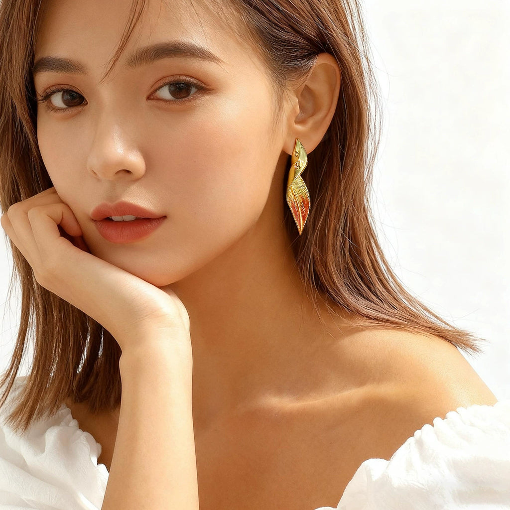 Model wearing Troveform textured red leaf stud earrings in gold-tone