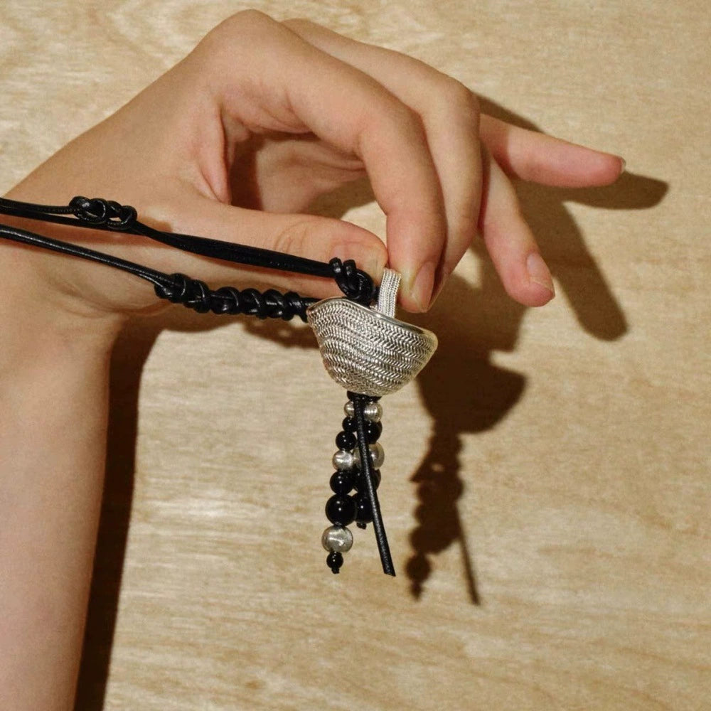 Black Onyx beads and textured silver-tone basket pendant detail